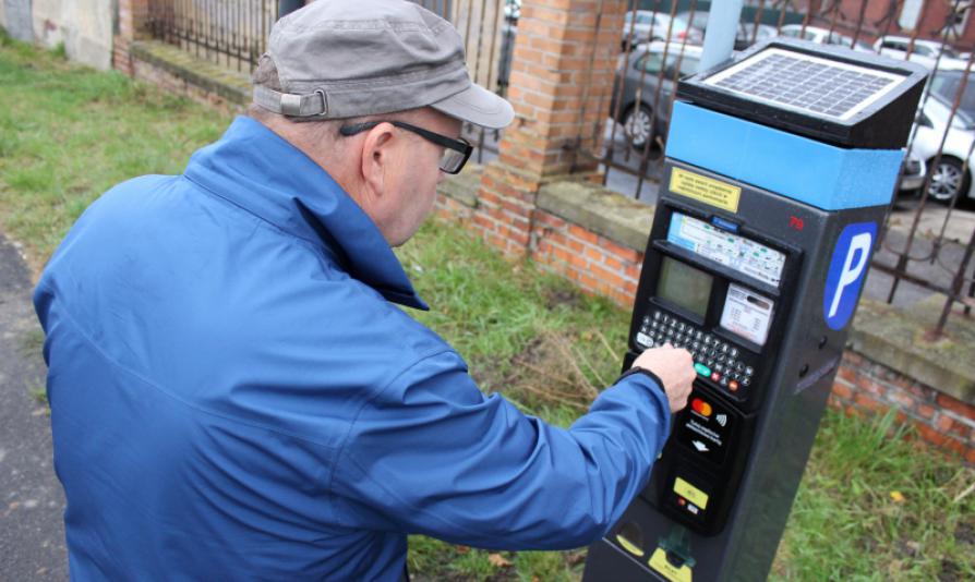 Na zdjęciu mężczyzna korzystający z parkomatu 