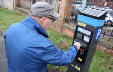 Na zdjęciu mężczyzna korzystający z parkomatu 