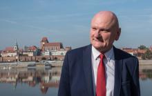 Zdjęcie Michała Zaleskiego - Prezydenta Torunia, w tle panorama miasta