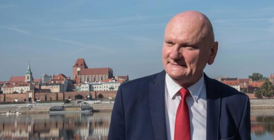 Zdjęcie Michała Zaleskiego - Prezydenta Torunia, w tle panorama miasta