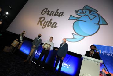 Przedstawiciele nowego laureata znaku uroczyście odbierają certyfikat na scenie